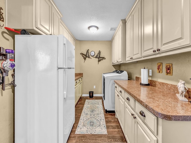 laundry area featuring cabinet space, dark wood-style flooring, a textured ceiling, baseboards, and visible vents
