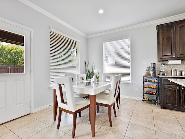 dining area with plenty of natural light, ornamental molding, baseboards, and light tile patterned floors