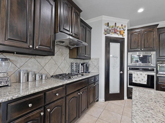 kitchen featuring under cabinet range hood, stainless steel appliances, tasteful backsplash, and dark brown cabinets