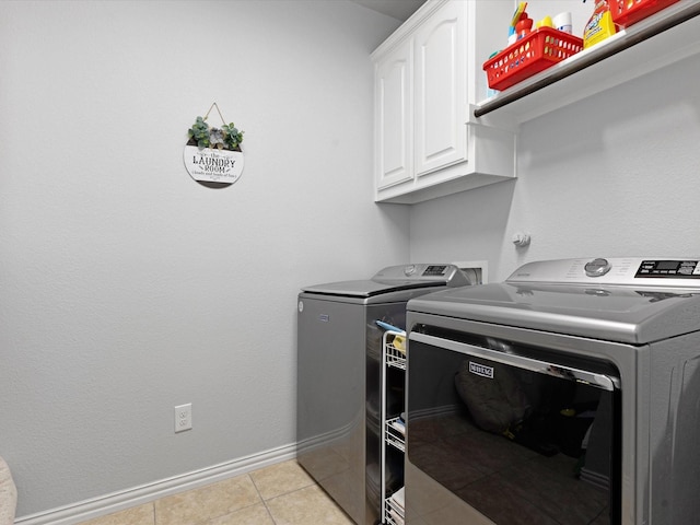laundry room featuring baseboards, cabinet space, independent washer and dryer, and light tile patterned floors