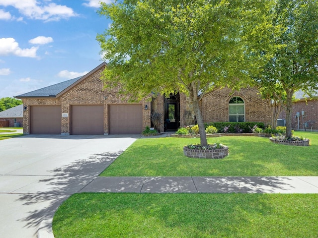 obstructed view of property with an attached garage, driveway, a front lawn, and brick siding
