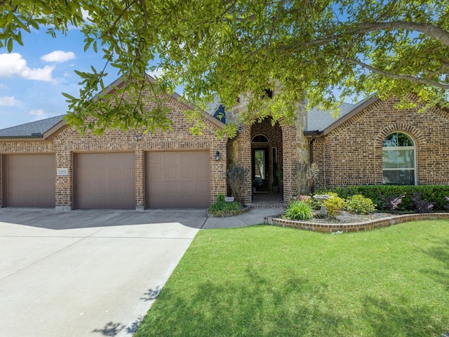 view of front of property with roof with shingles, a front lawn, brick siding, a garage, and concrete driveway