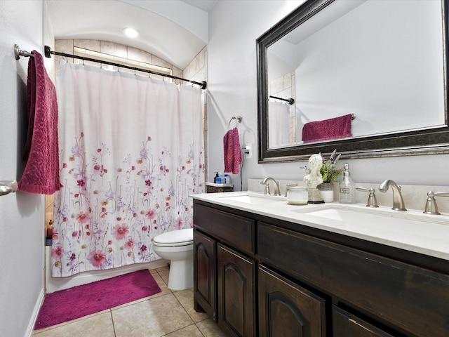 bathroom with tile patterned flooring, a sink, double vanity, and toilet
