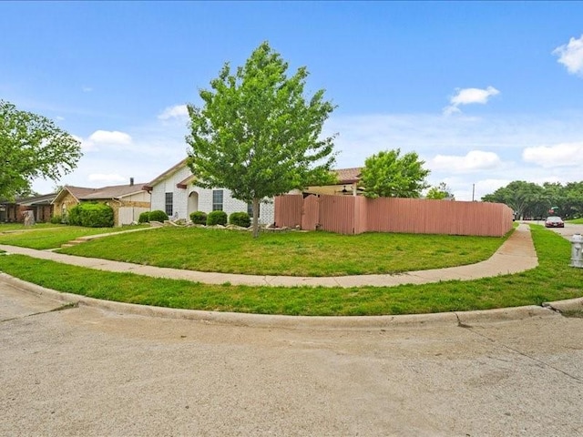 view of side of property featuring a lawn and fence