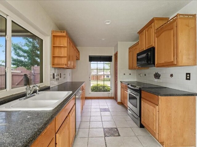 kitchen with appliances with stainless steel finishes, tasteful backsplash, open shelves, a sink, and light tile patterned floors
