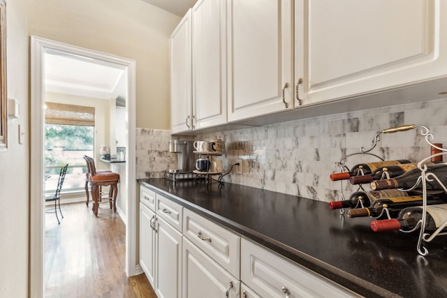 bar featuring backsplash and wood finished floors