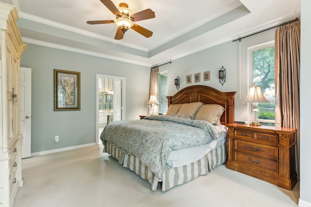 bedroom with ornamental molding, baseboards, light colored carpet, a tray ceiling, and a ceiling fan