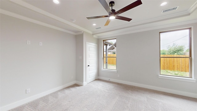 empty room featuring plenty of natural light, a ceiling fan, light colored carpet, and visible vents