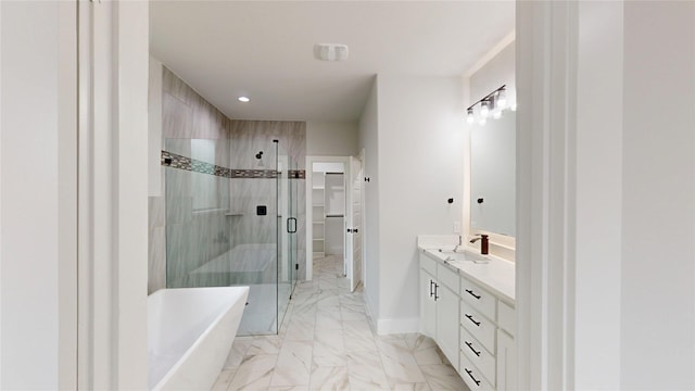 bathroom featuring vanity, marble finish floor, a shower stall, a spacious closet, and a soaking tub
