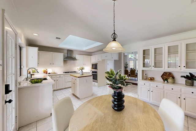 dining space with a skylight and light tile patterned floors