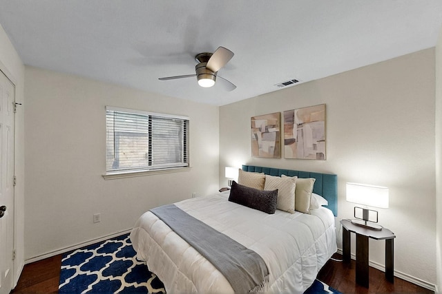 bedroom with ceiling fan, dark wood-type flooring, and baseboards