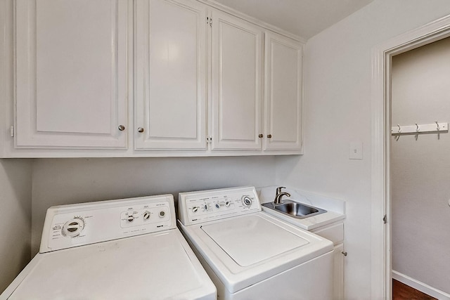 washroom featuring separate washer and dryer, cabinet space, and baseboards