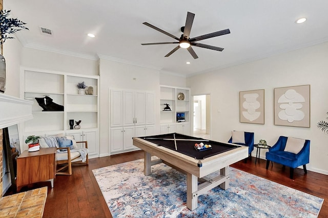 game room with dark wood-style flooring, ceiling fan, ornamental molding, built in shelves, and recessed lighting