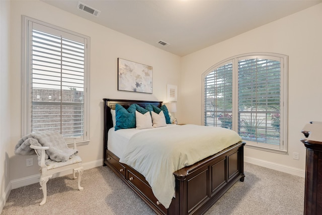 bedroom with baseboards, light colored carpet, and visible vents