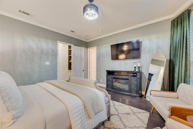 bedroom featuring crown molding, dark wood finished floors, and visible vents