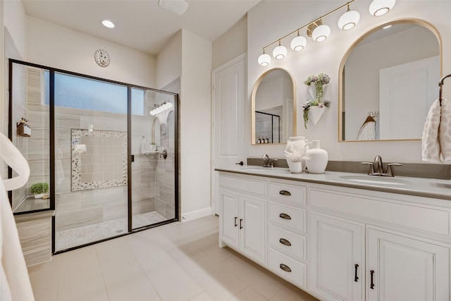 bathroom with a sink, baseboards, a tile shower, and double vanity