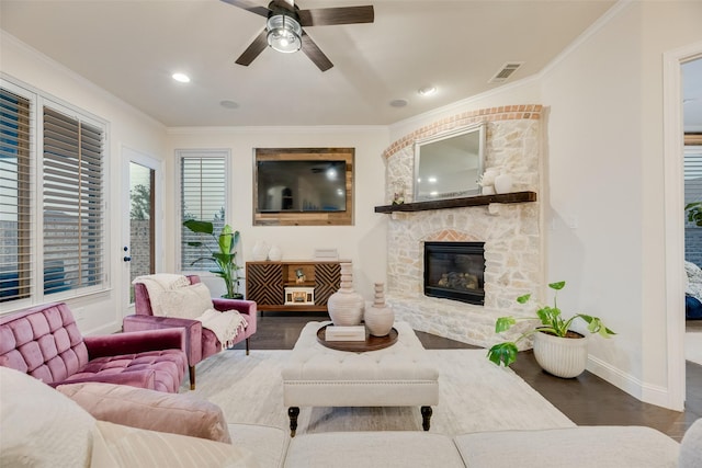 living room with visible vents, ceiling fan, wood finished floors, and a fireplace