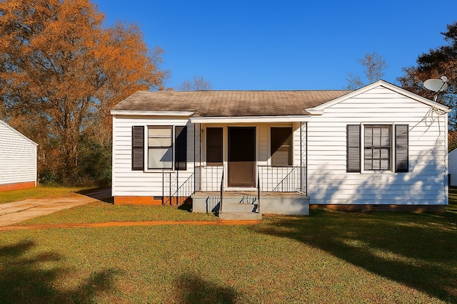 bungalow-style house with crawl space, a shingled roof, and a front yard