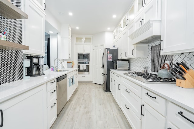 kitchen featuring stainless steel appliances, open shelves, a sink, and premium range hood