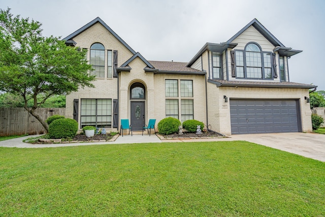 view of front of property featuring a front yard, brick siding, fence, concrete driveway, and an attached garage