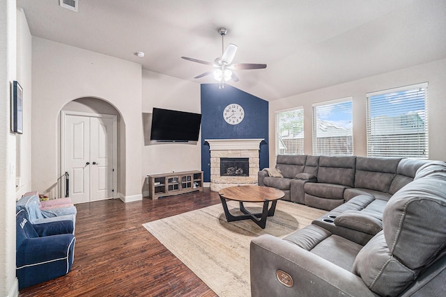 living area featuring ceiling fan, dark wood finished floors, vaulted ceiling, a fireplace, and baseboards