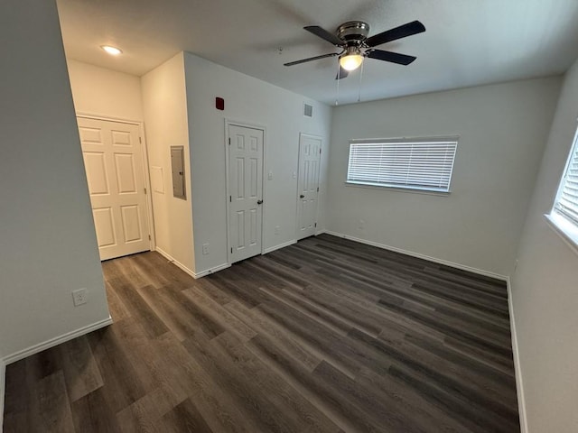 empty room with baseboards, plenty of natural light, a ceiling fan, and dark wood-style floors