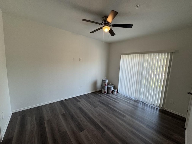 unfurnished room with baseboards, a ceiling fan, and dark wood finished floors