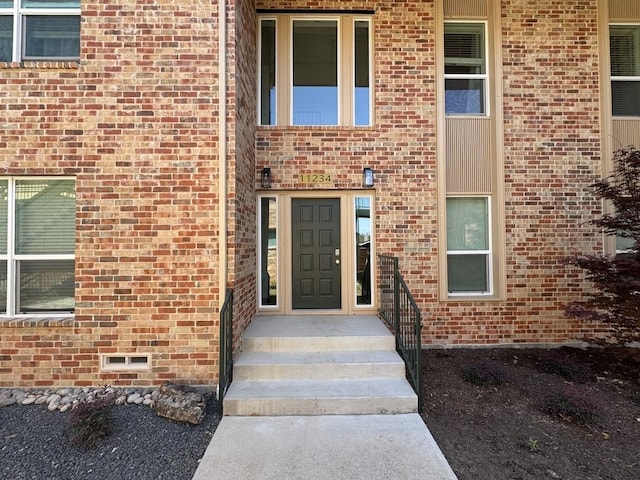 doorway to property with brick siding