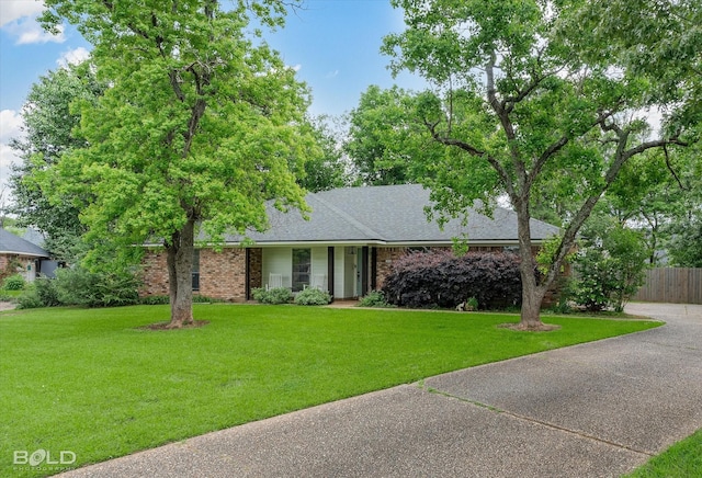single story home featuring fence, a front lawn, and brick siding