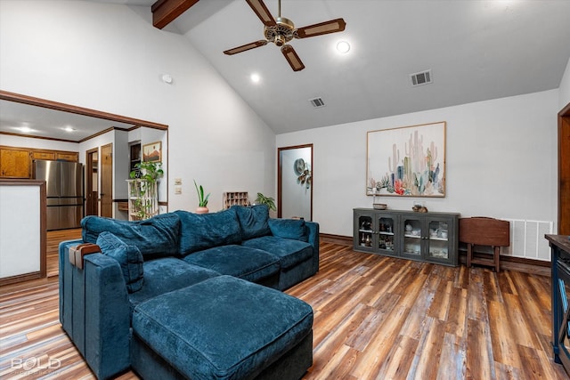 living area featuring visible vents, a ceiling fan, light wood finished floors, and beamed ceiling