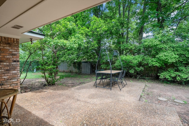 view of patio with outdoor dining area, a fenced backyard, and visible vents
