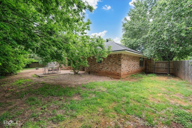 view of yard featuring a patio, a fenced backyard, and a gate