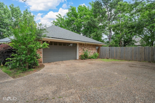 garage featuring fence and driveway