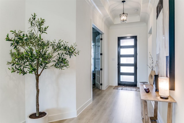 foyer featuring crown molding, baseboards, and light wood finished floors