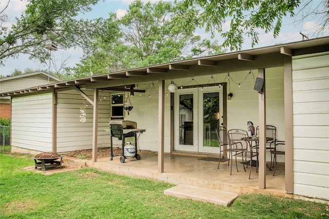 back of house featuring a yard, a patio, and an outdoor fire pit