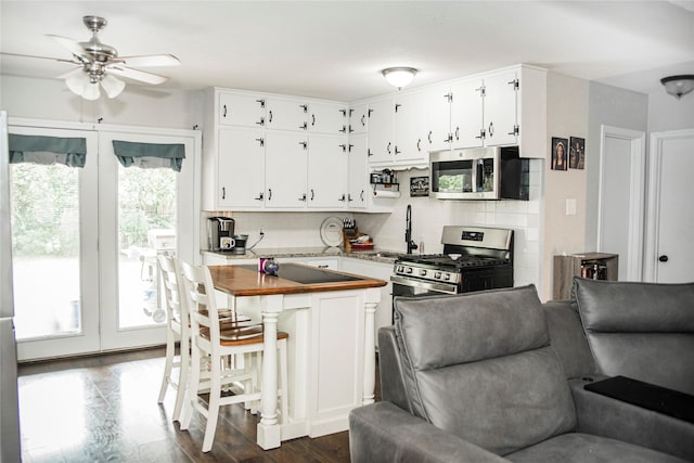 kitchen featuring backsplash, white cabinetry, appliances with stainless steel finishes, and a sink