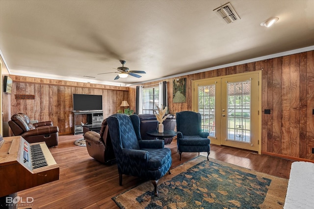 living area featuring visible vents, ornamental molding, and a healthy amount of sunlight