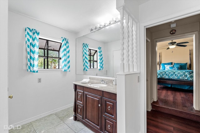 ensuite bathroom with tile patterned flooring, vanity, ensuite bath, a ceiling fan, and baseboards