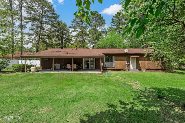 rear view of property with a yard, entry steps, fence, and a patio area