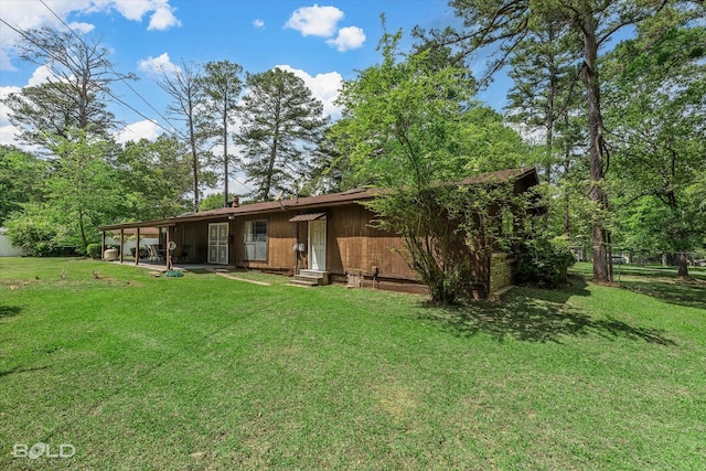 back of property featuring fence, entry steps, a yard, and a patio area
