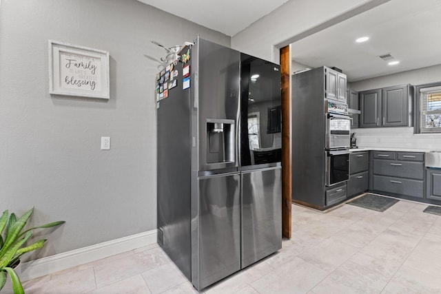 kitchen with double oven, light countertops, gray cabinets, fridge with ice dispenser, and visible vents