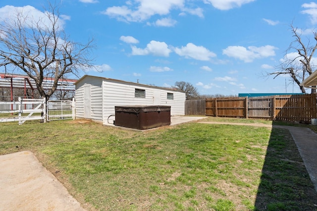 view of yard with an outdoor structure, a fenced backyard, and a hot tub