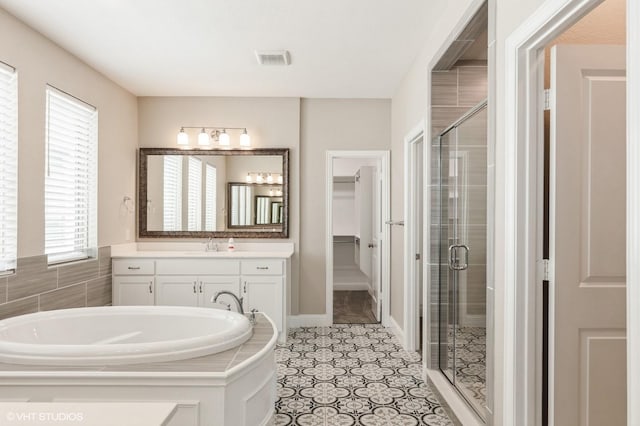 full bath featuring visible vents, a stall shower, and a wealth of natural light