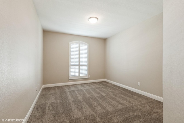 carpeted spare room with baseboards