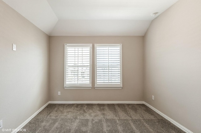 unfurnished room with carpet floors, baseboards, and lofted ceiling