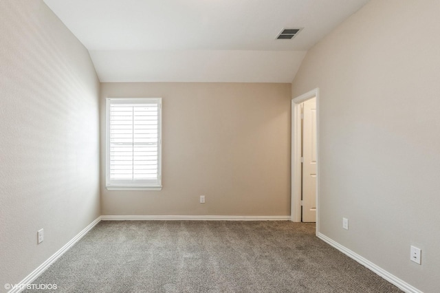 unfurnished room with carpet floors, baseboards, visible vents, and lofted ceiling
