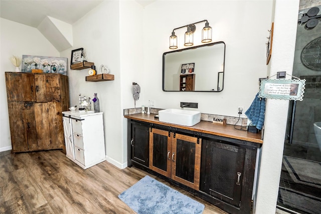 bar with baseboards, a sink, and wood finished floors