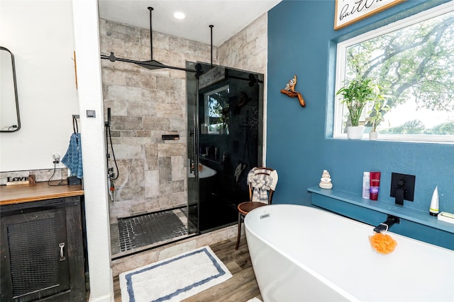 full bath with wood finished floors, a soaking tub, and a stall shower