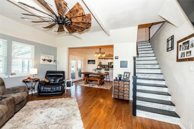 living area featuring a notable chandelier, plenty of natural light, wood finished floors, and stairway