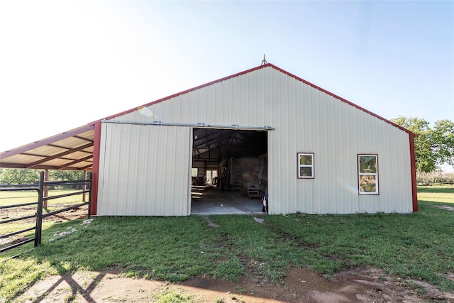 view of pole building with fence and a yard